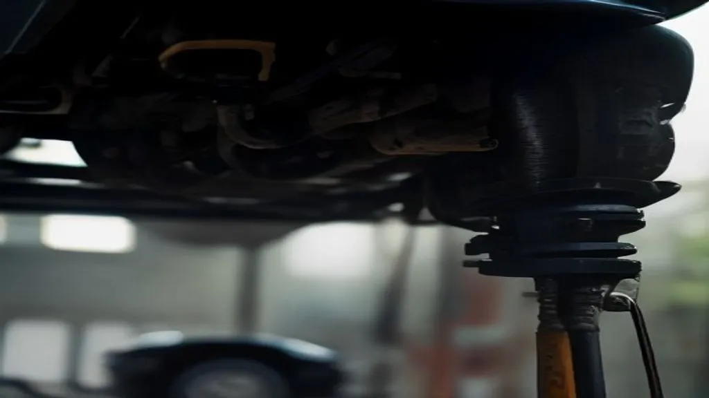 Mecânico inspecionando a suspensão dianteira de um carro elevado numa oficina