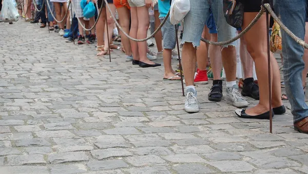Pessoas em fila aguardando atendimento — ilustração do problema da espera em estações de recarga